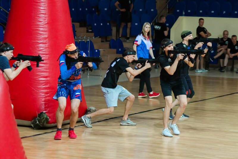 Игроки LASERWAR в движении, занимая позиции у надувных укрытий.